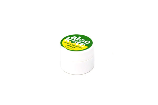 Small white container with green and yellow top of sunscreen.