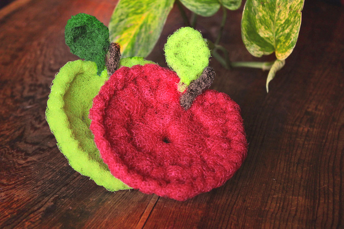 red and green apple scrubbies with wood and leaf background