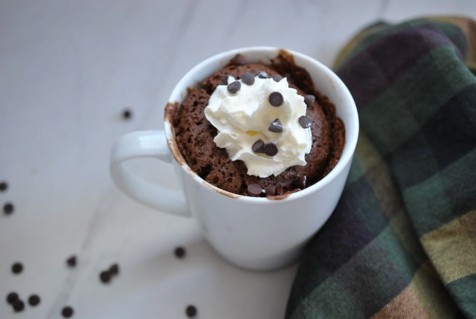 Mug full of cake and whipped cream.