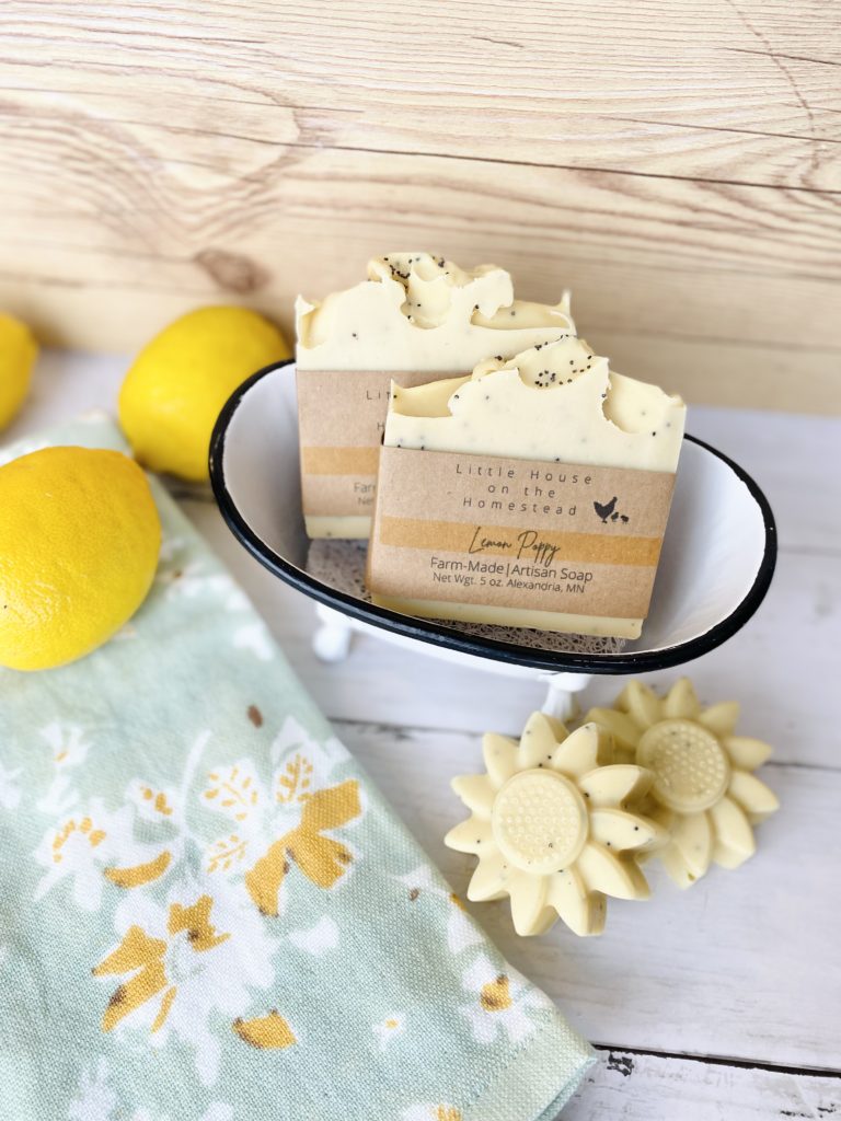 Yellow soap set on a table in a bowl alongside a blue cloth and lemons.