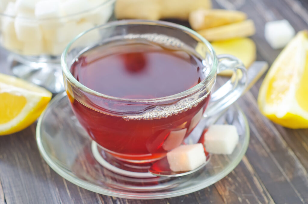 A cup of tea with two cubes of sugar and lemon